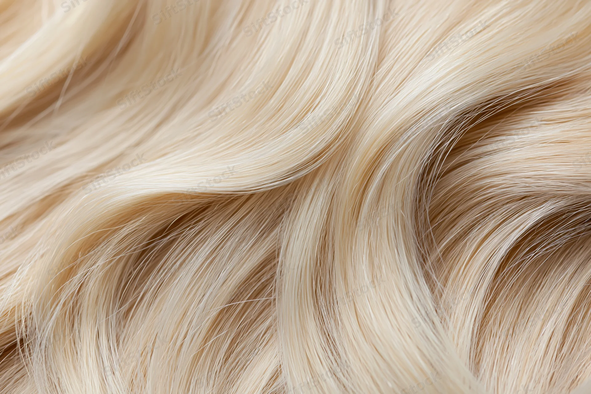 Close-up of wavy blonde hair strands laid flat showing texture and shine