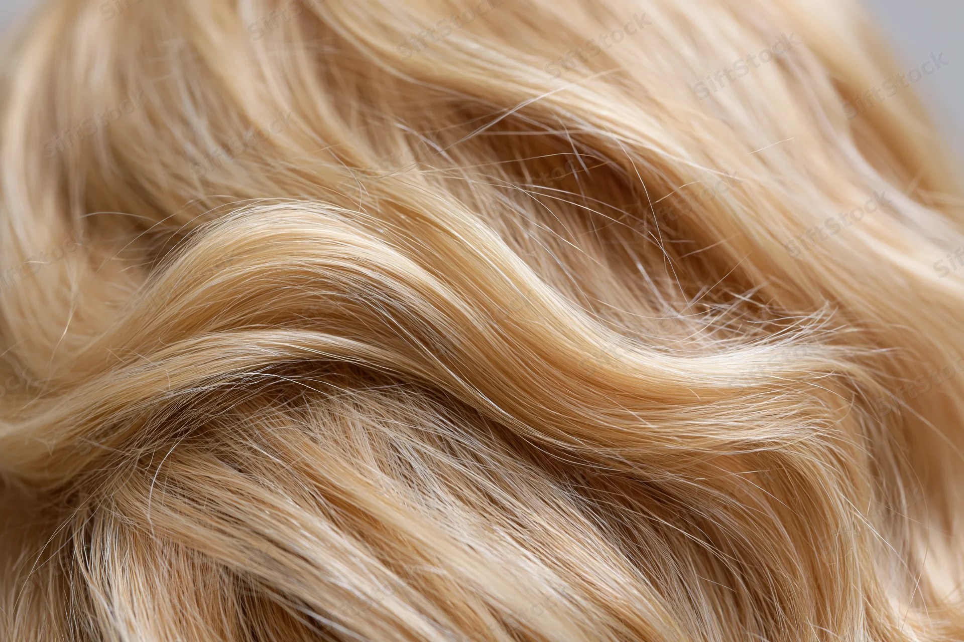 Close-up of wavy blonde human hair with natural texture and shine