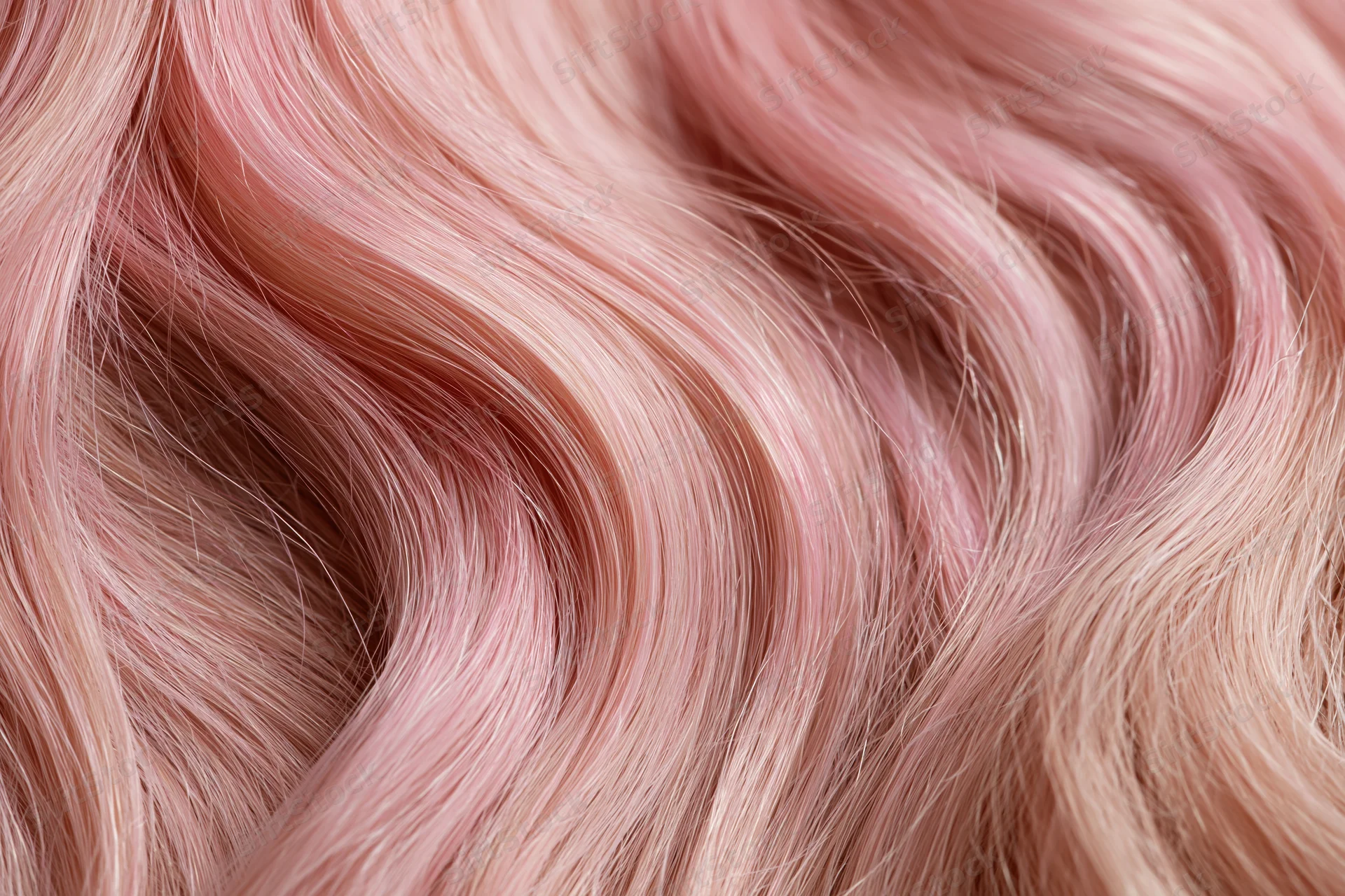 Close-up of wavy pink-dyed human hair filling the frame
