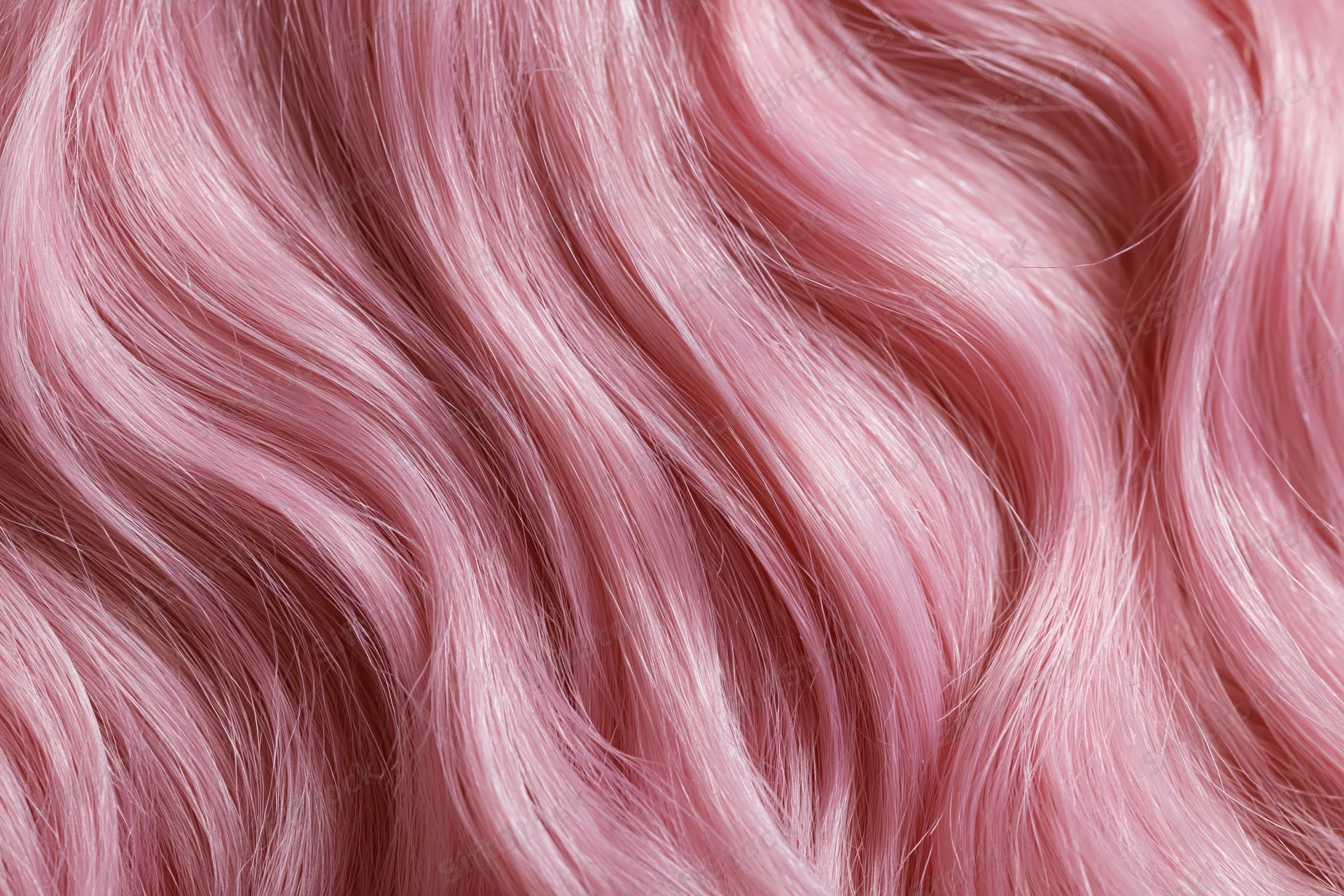 Close-up of wavy pink-dyed human hair filling the frame
