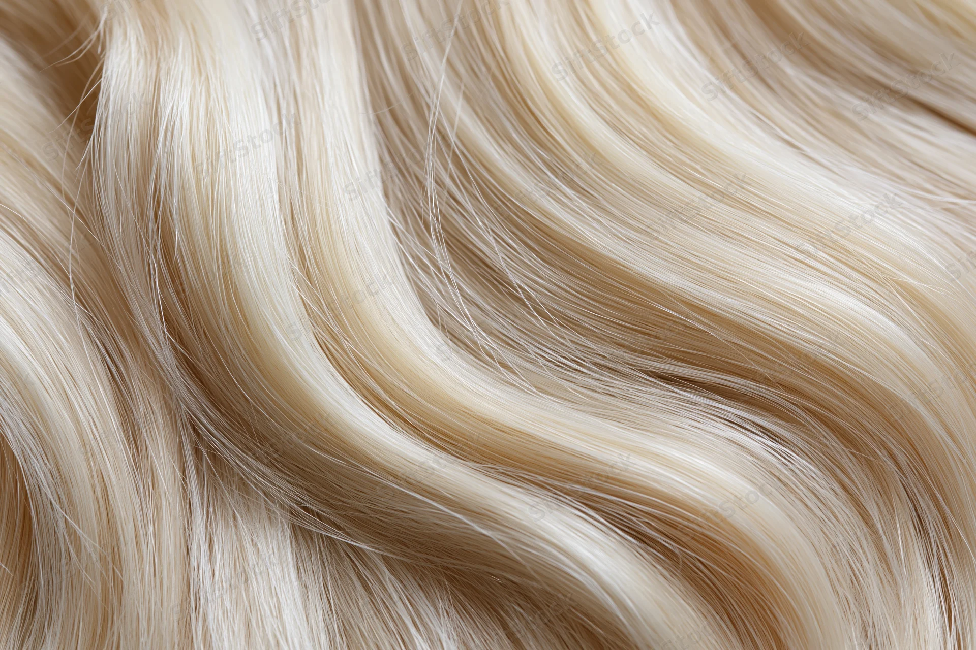 Close-up of flowing platinum blonde hair strands with smooth shiny texture