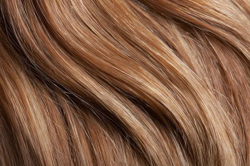 Close-up of straight honey-blonde human hair showing smooth texture and natural shine