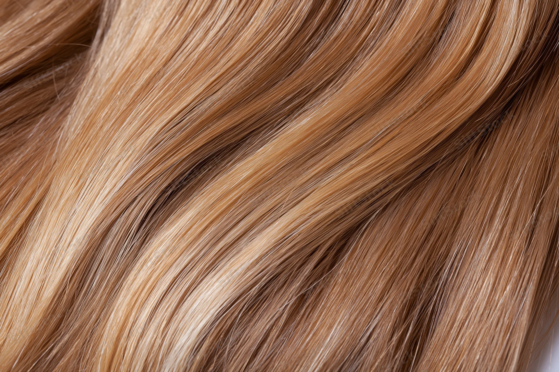 Close-up of straight honey-blonde human hair showing smooth texture and natural shine