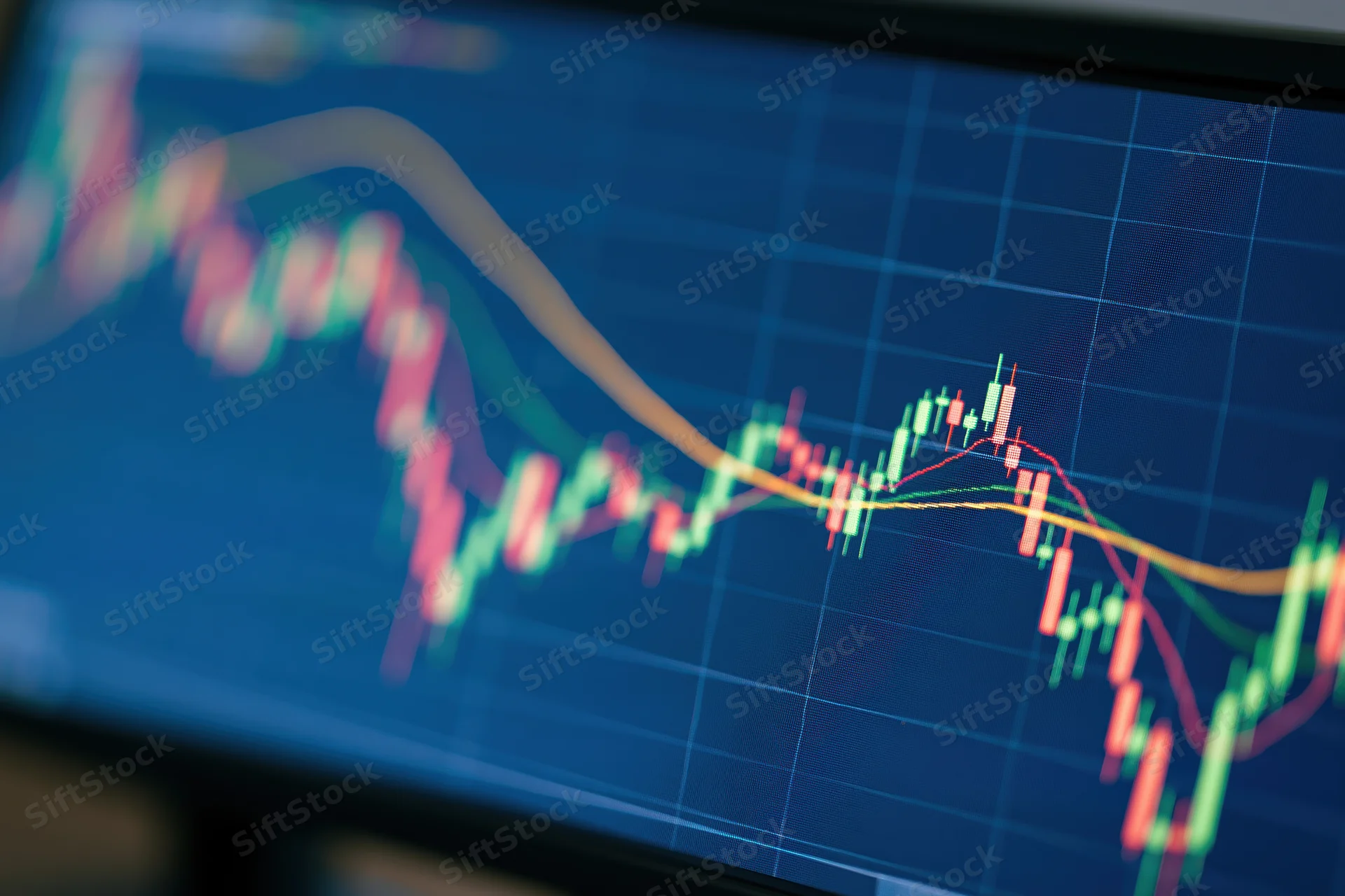 Close-up of a trading monitor screen displaying candlestick chart with price trends and grid lines
