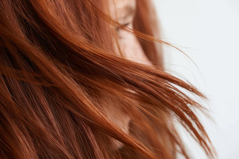 Close-up of flowing auburn red hair mid-motion locks curving