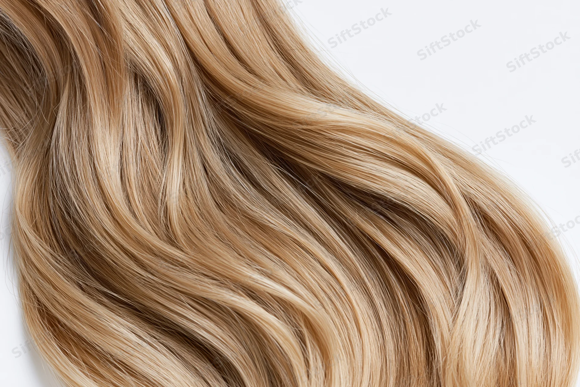 Close-up of loose wavy blonde hair strands arranged in soft flowing waves against white background