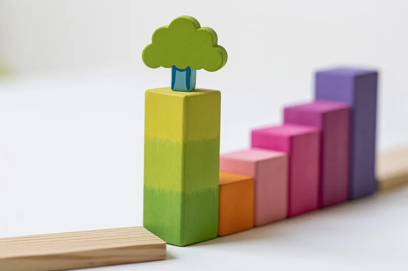 Colorful wooden blocks arranged in ascending staircase with tree symbol on top
