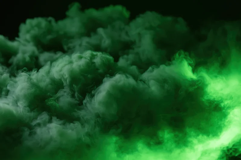 Dense green smoke billowing and swirling in dark space