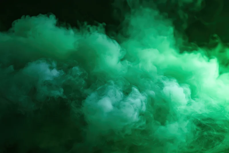 Dense green smoke billowing and swirling in dark space