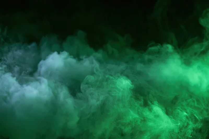 Dense billowing green smoke swirling in dark space