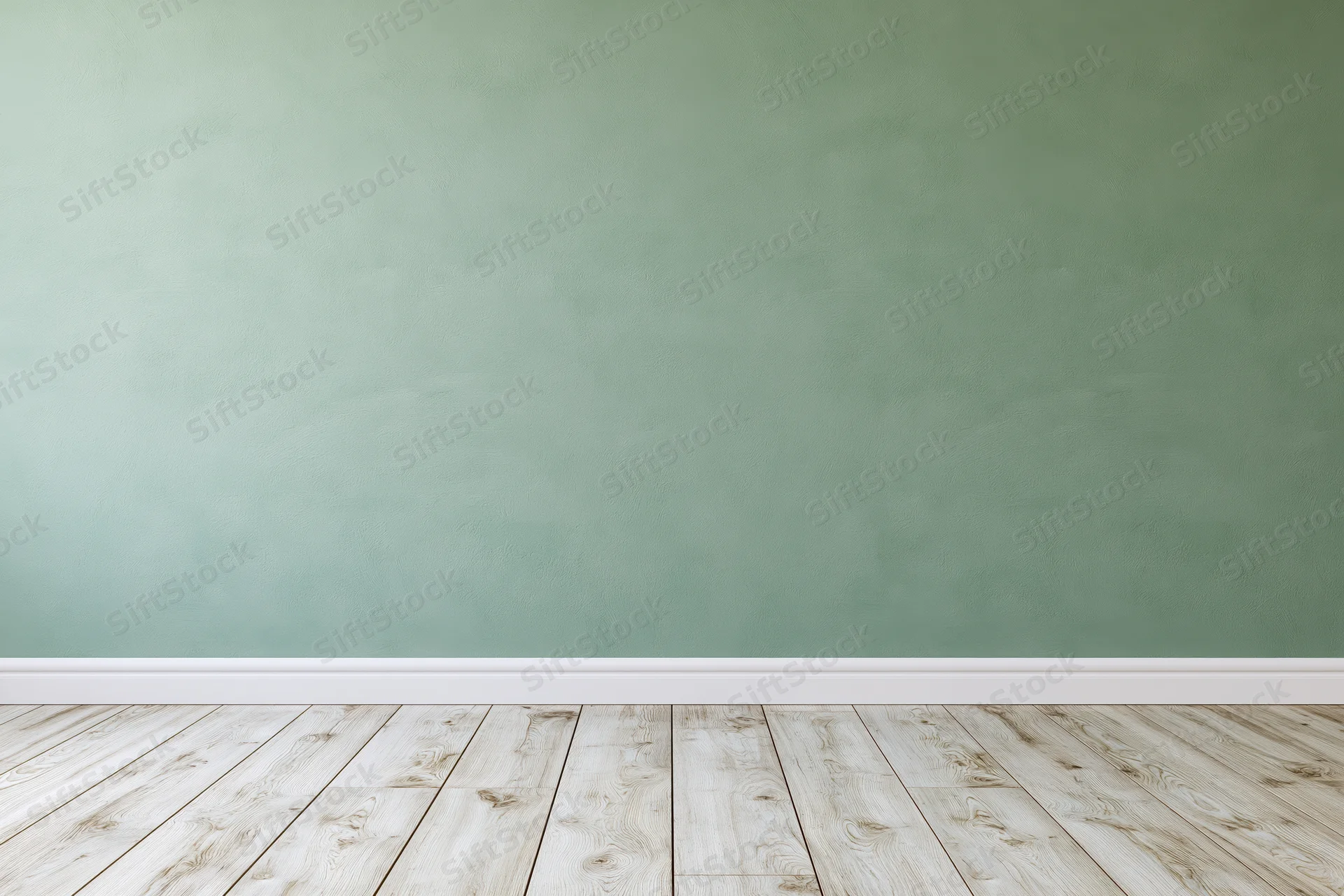 Empty room with sage green painted wall and light wooden floor
