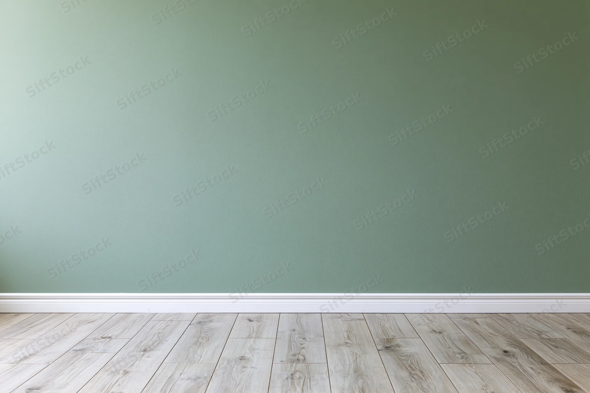 Empty room with sage green painted wall and light wood flooring