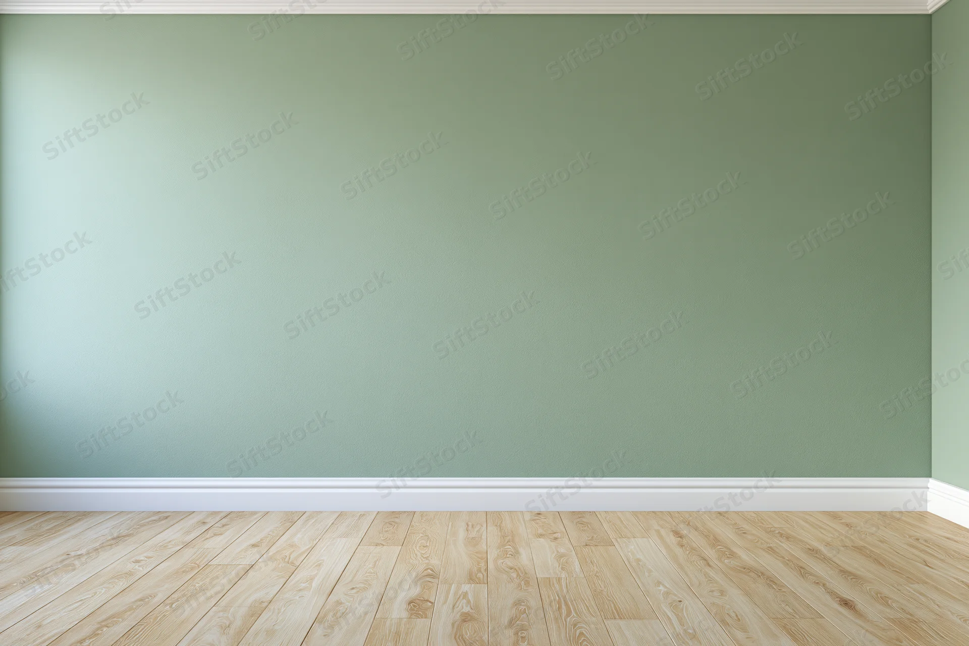 Empty room with sage green painted wall and wooden floor, white baseboard trim along the corner