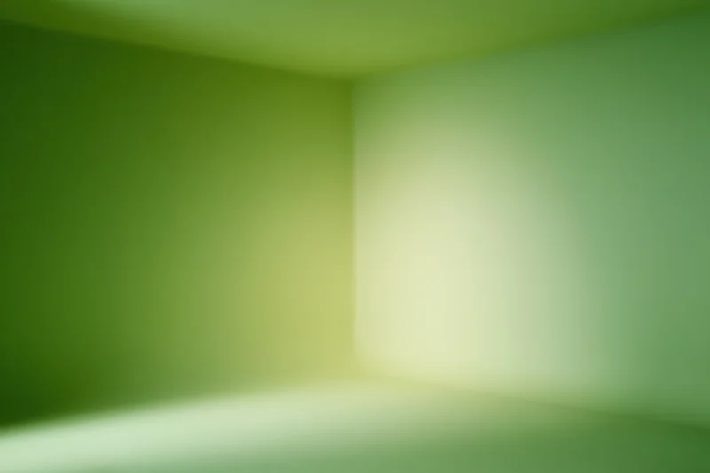 Empty studio corner with smooth green gradient backdrop and soft lighting