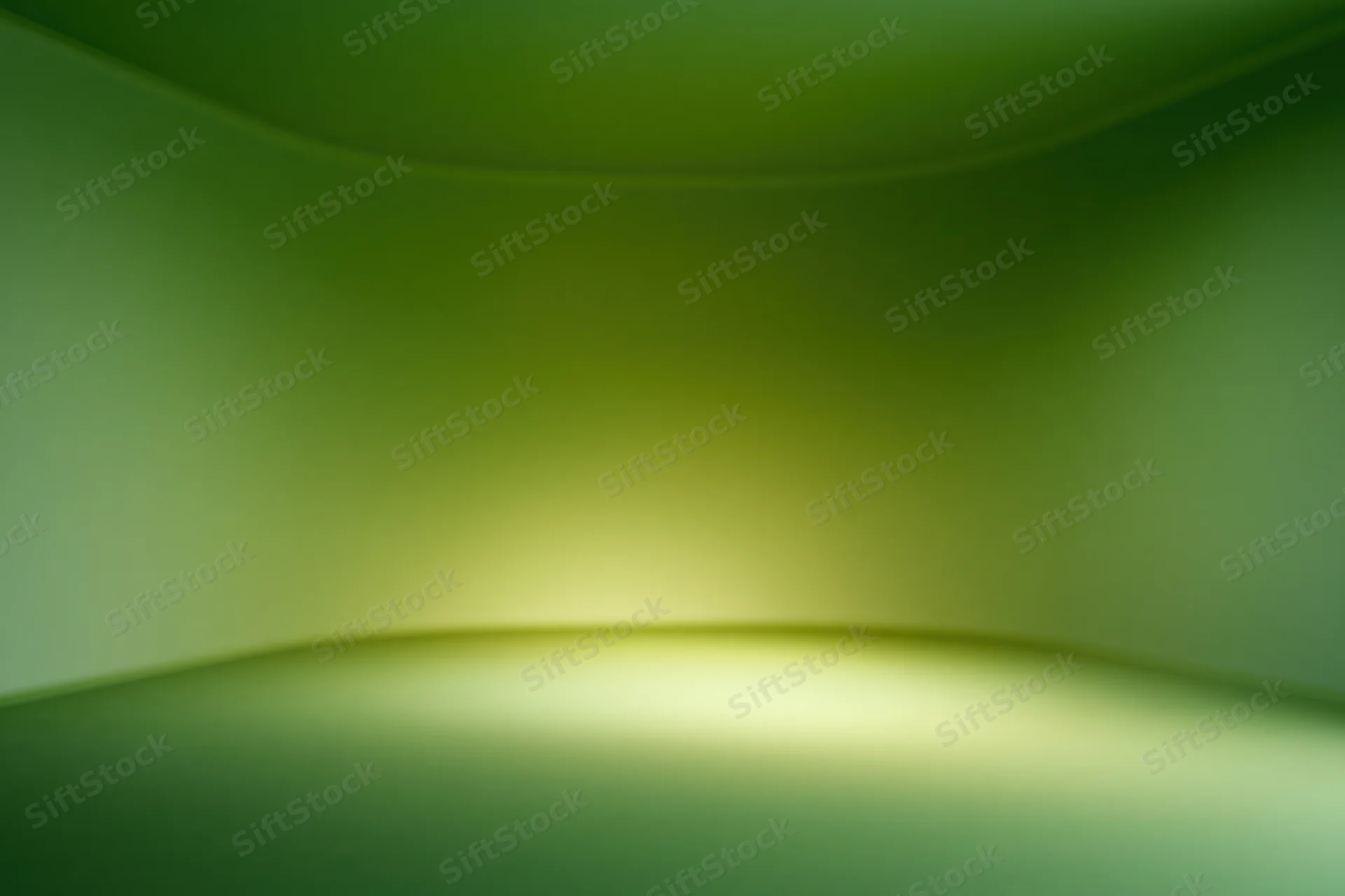 Smooth curved green gradient studio backdrop with soft lighting and empty space