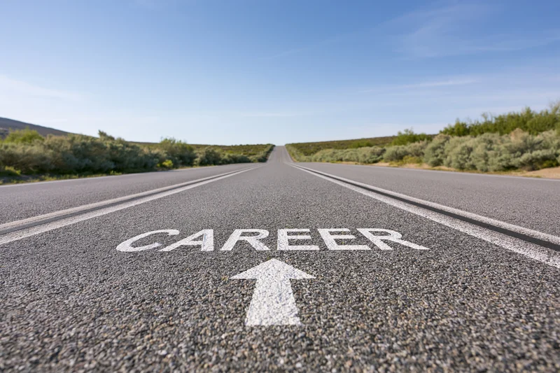 Asphalt road with career arrow marking stretching straight to horizon