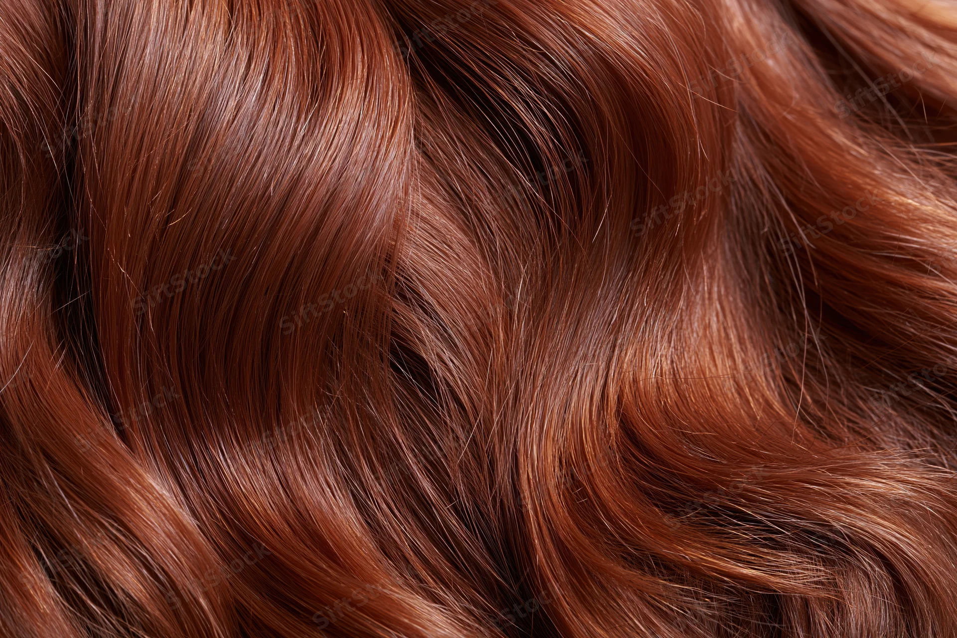 Flowing auburn red hair in close-up macro view showing wavy texture and shine