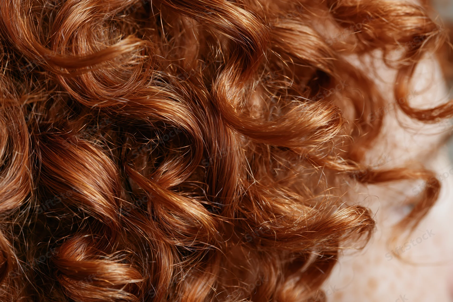 Extreme close-up of natural curly auburn hair showing texture and volume