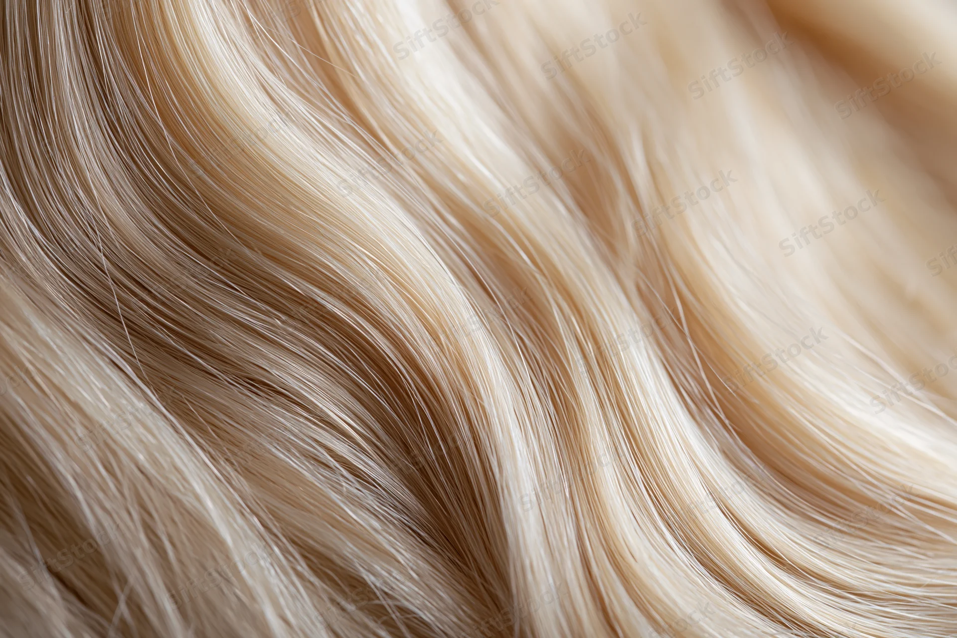 Extreme close-up of platinum blonde human hair strands showing smooth texture and natural shine
