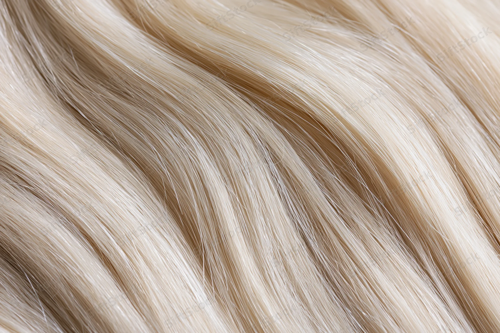 Extreme close-up of platinum blonde human hair strands showing smooth texture and natural shine