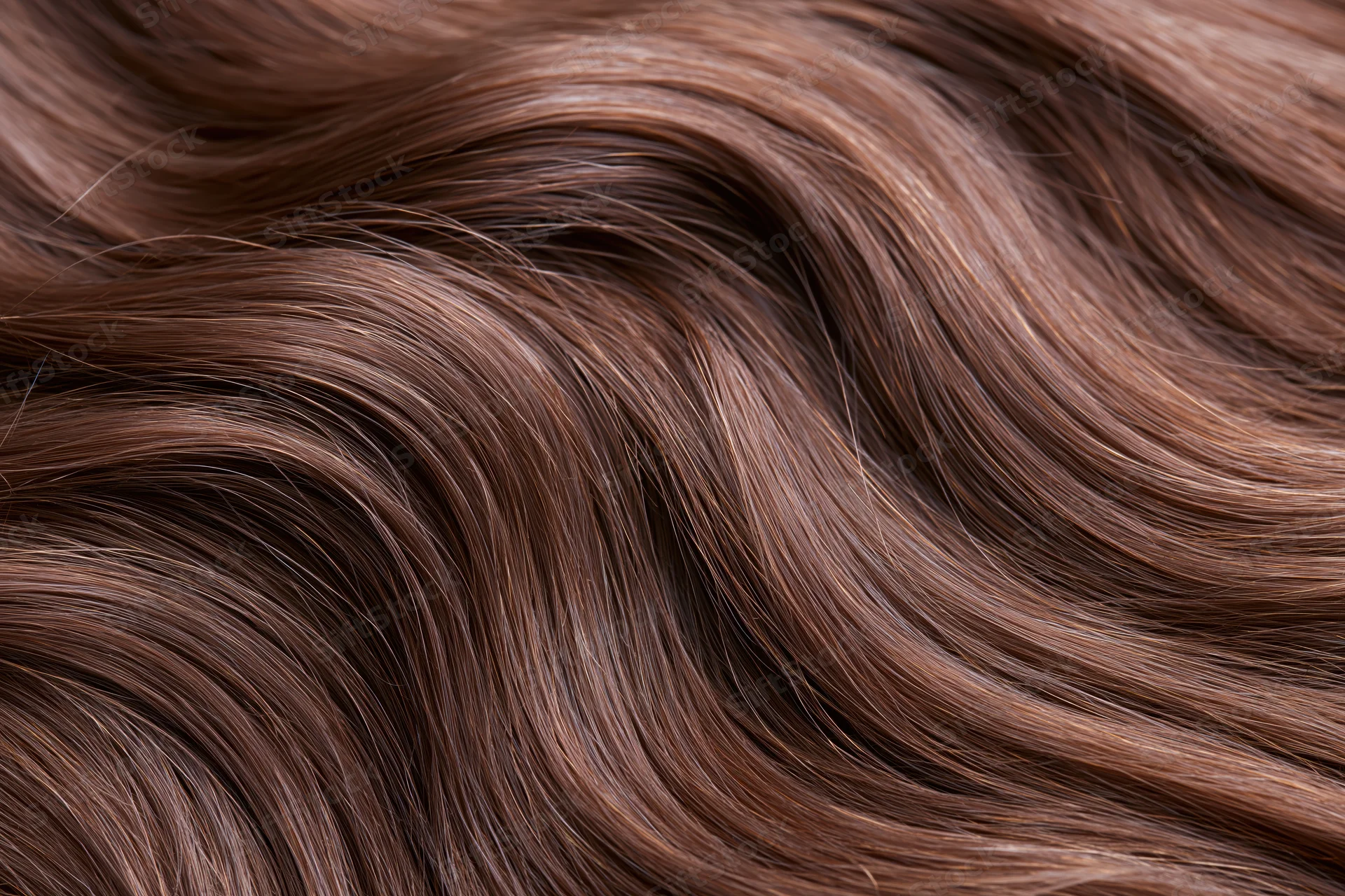 Close-up of smooth wavy brown hair filling the frame