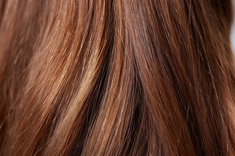 Closeup of straight brown hair strands showing smooth texture and shine
