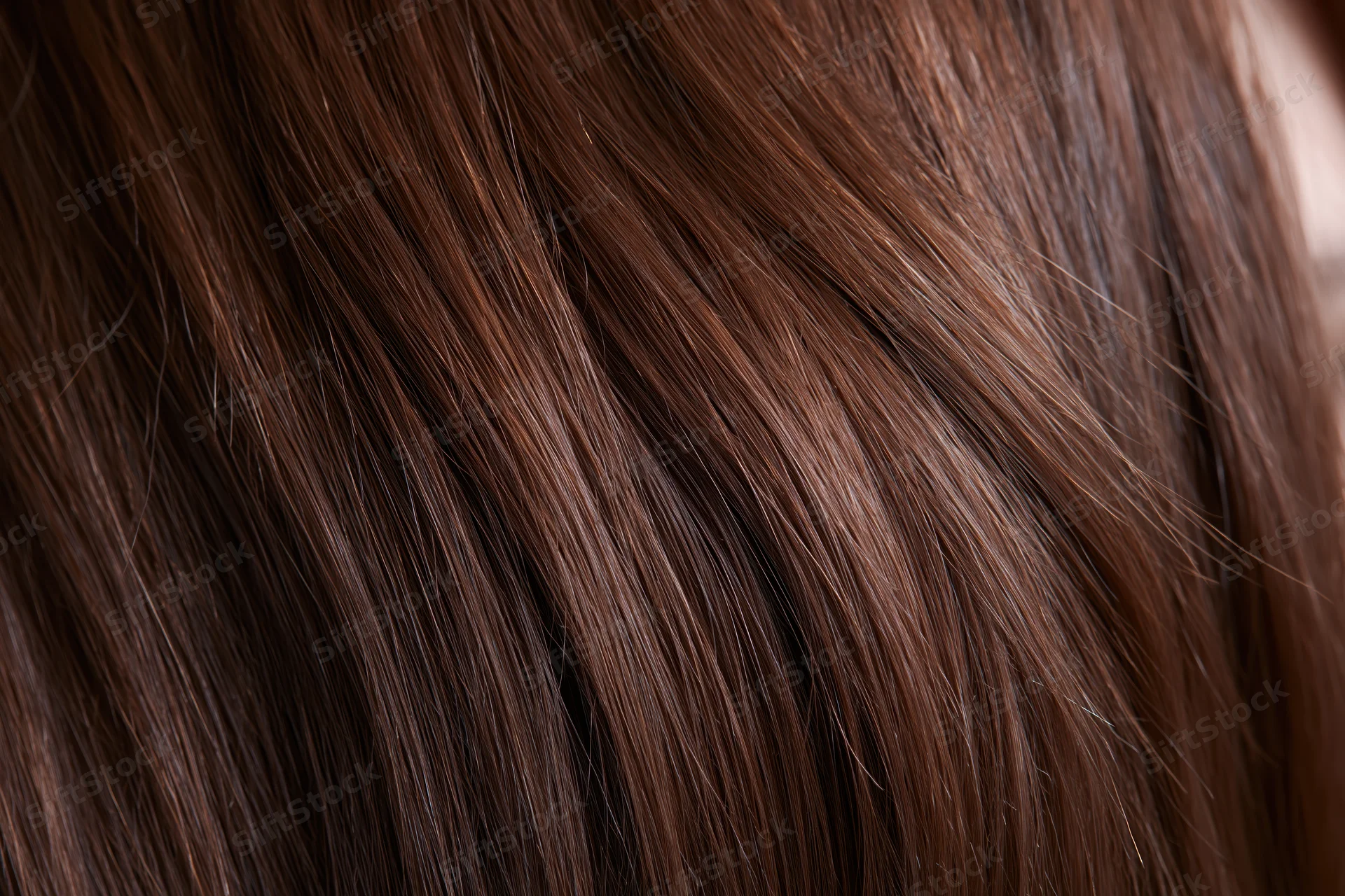 Close-up of straight brown hair strands showing smooth texture and shine