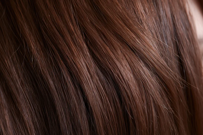 Close-up of straight brown hair strands showing smooth texture and shine