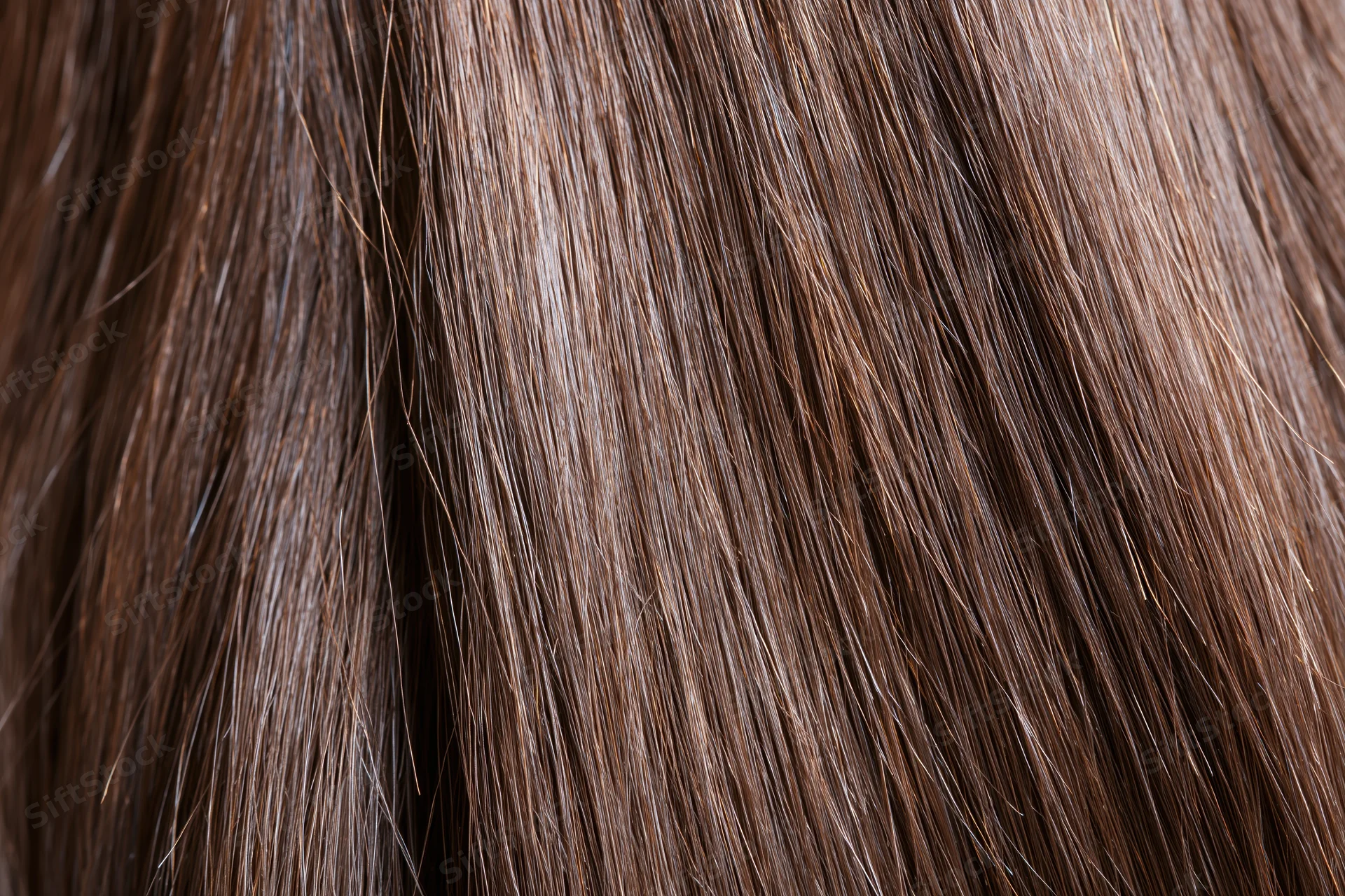 Extreme close-up of straight brown hair strands showing texture and shine