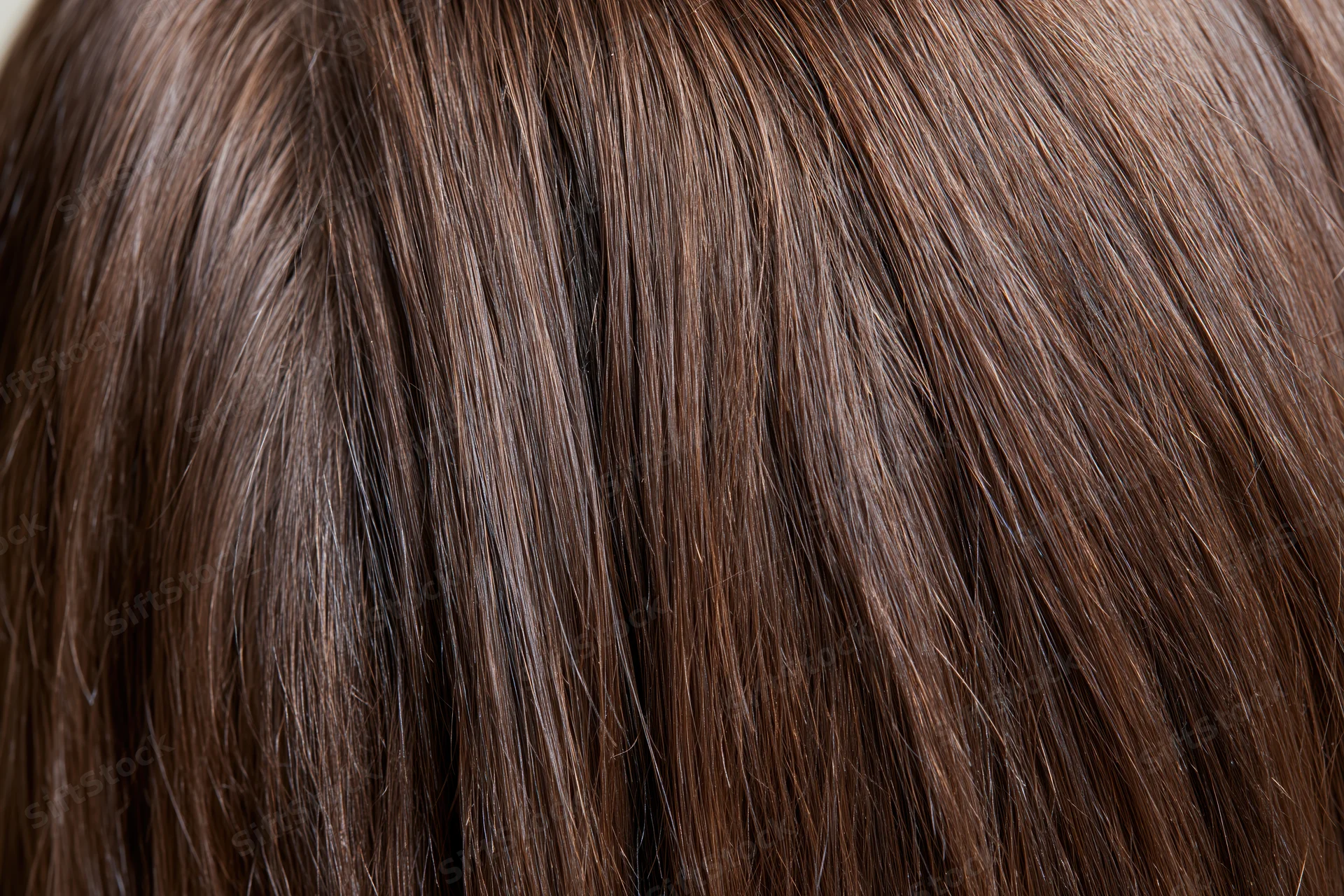 Closeup of straight brown hair strands showing smooth texture and natural shine