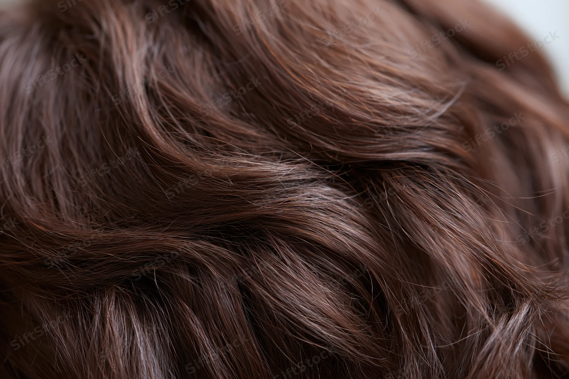 Closeup of wavy brown human hair filling the frame