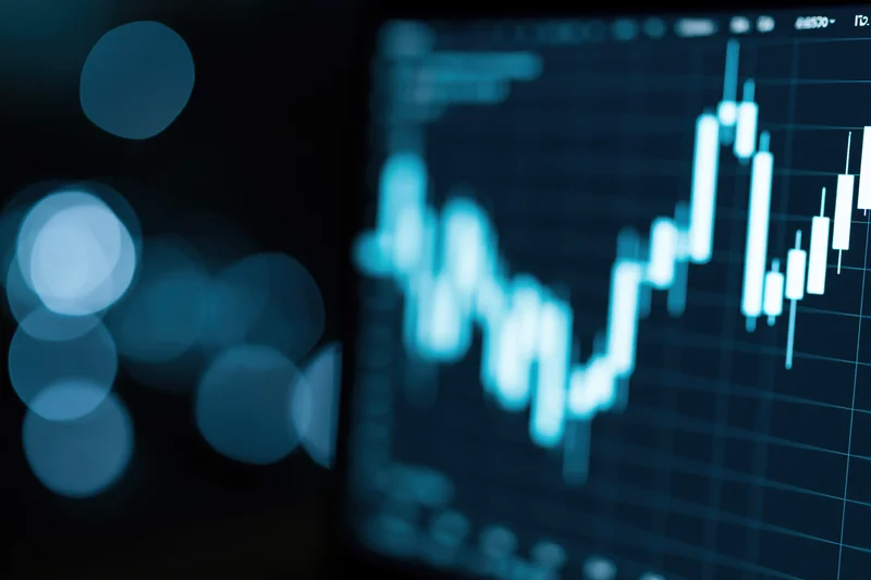 Financial candlestick chart showing upward trend on a dark digital screen