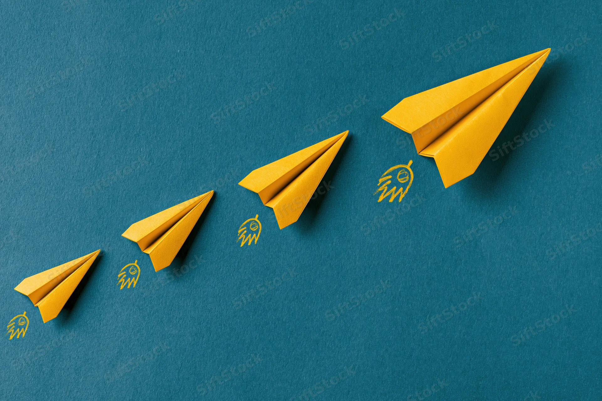 Five yellow paper airplanes arranged in ascending diagonal line on blue background