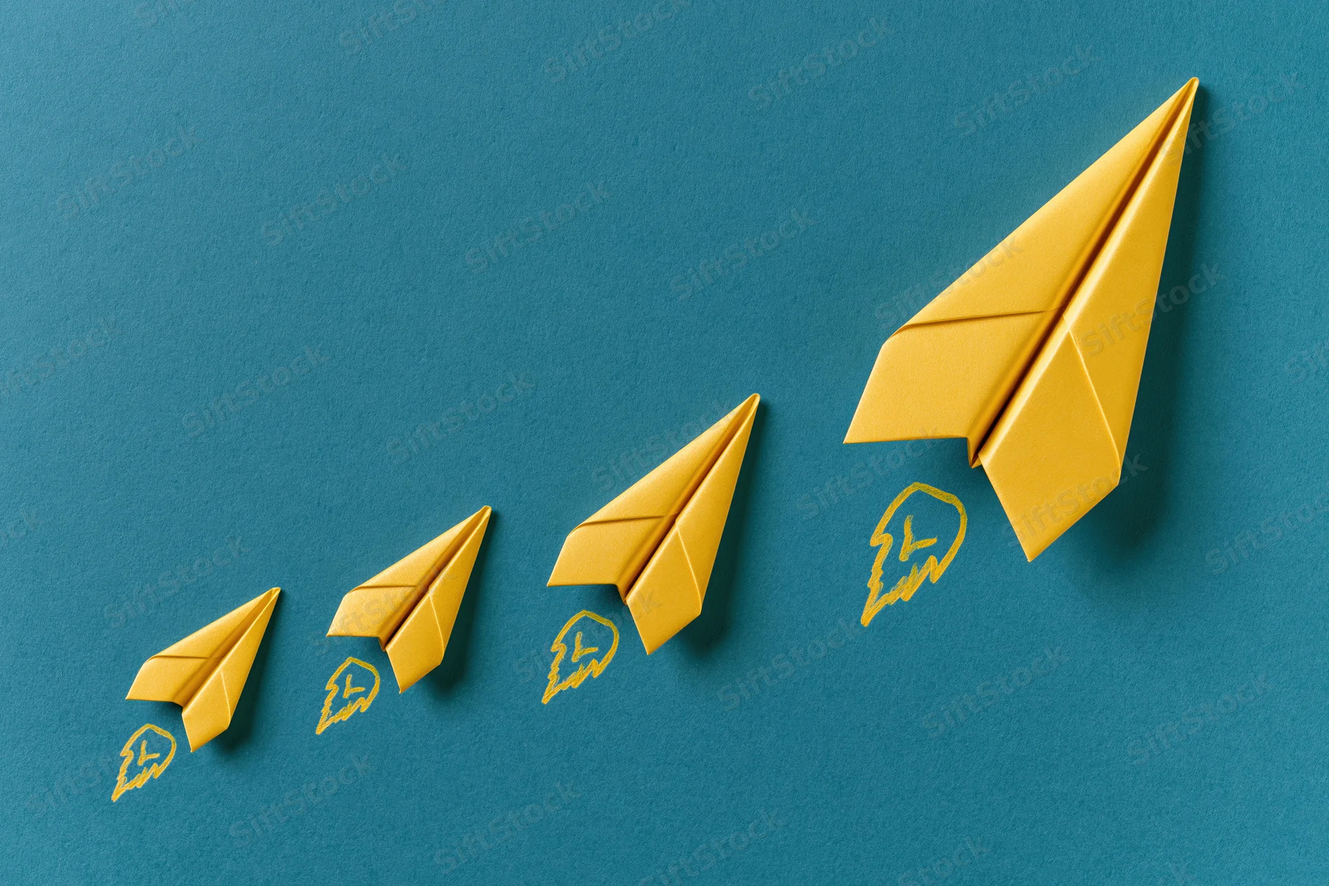 Five yellow paper airplanes arranged in ascending diagonal line on blue background