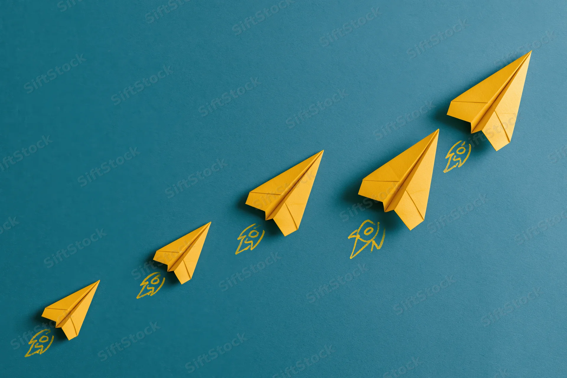 Five yellow paper airplanes arranged in ascending diagonal line on blue background