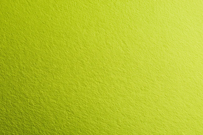 Close-up of smooth lime green paper surface with fine texture