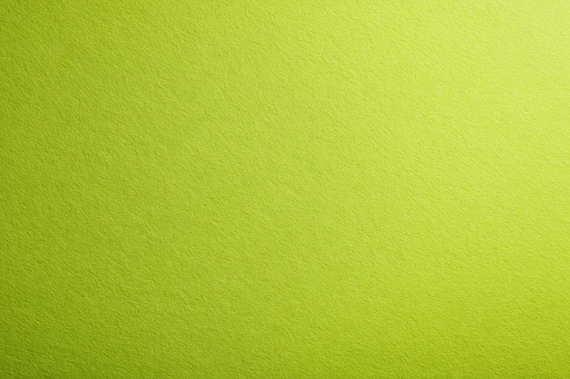 Close-up of smooth lime green paper surface with even texture and subtle gradient