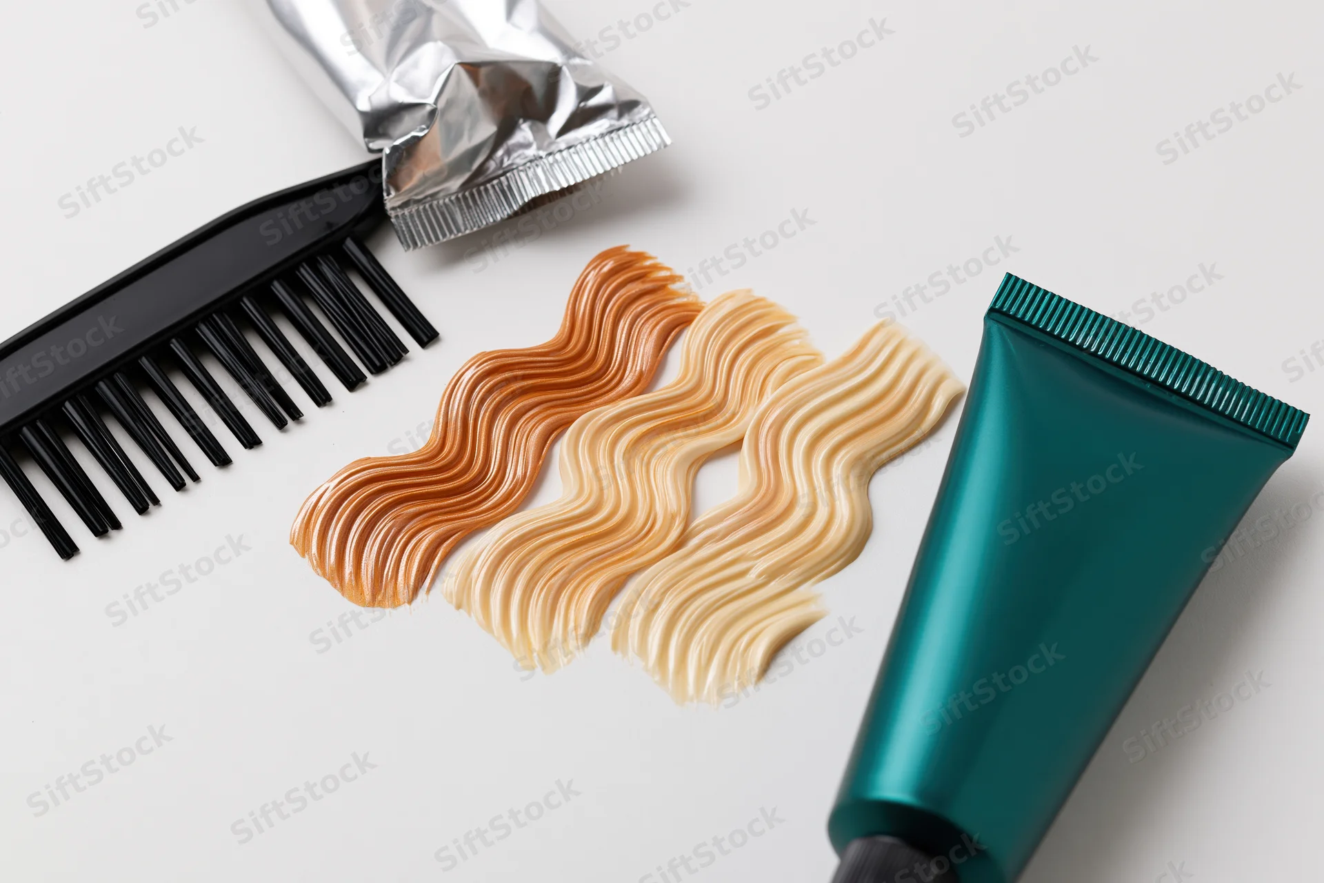 Hair dye swatches and tools arranged on white surface