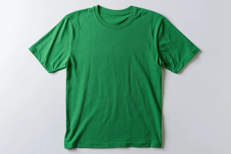 Plain green cotton t-shirt laid flat on white background