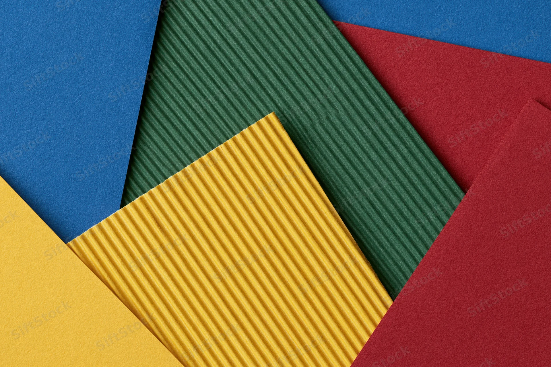 Overlapping sheets of colored construction paper arranged in a flat lay composition