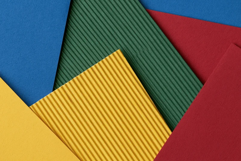 Overlapping sheets of colored construction paper arranged in a flat lay composition