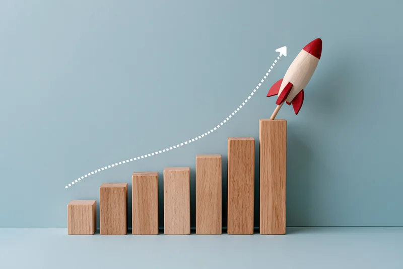 Wooden blocks arranged in ascending order with a toy rocket launching from the tallest one against a plain blue background