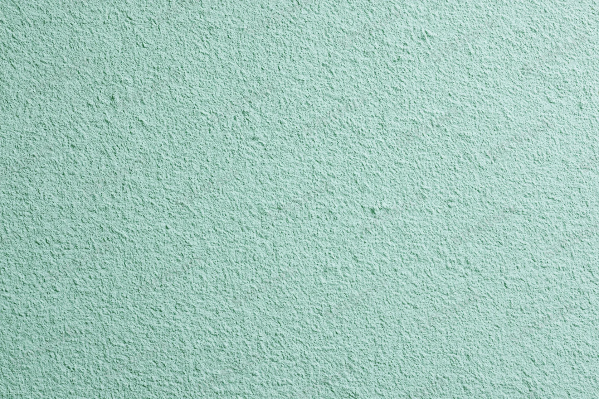 Close-up of a flat matte green painted wall surface filling the frame