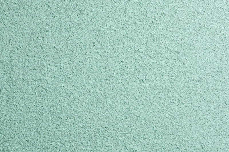 Close-up of a flat matte green painted wall surface filling the frame