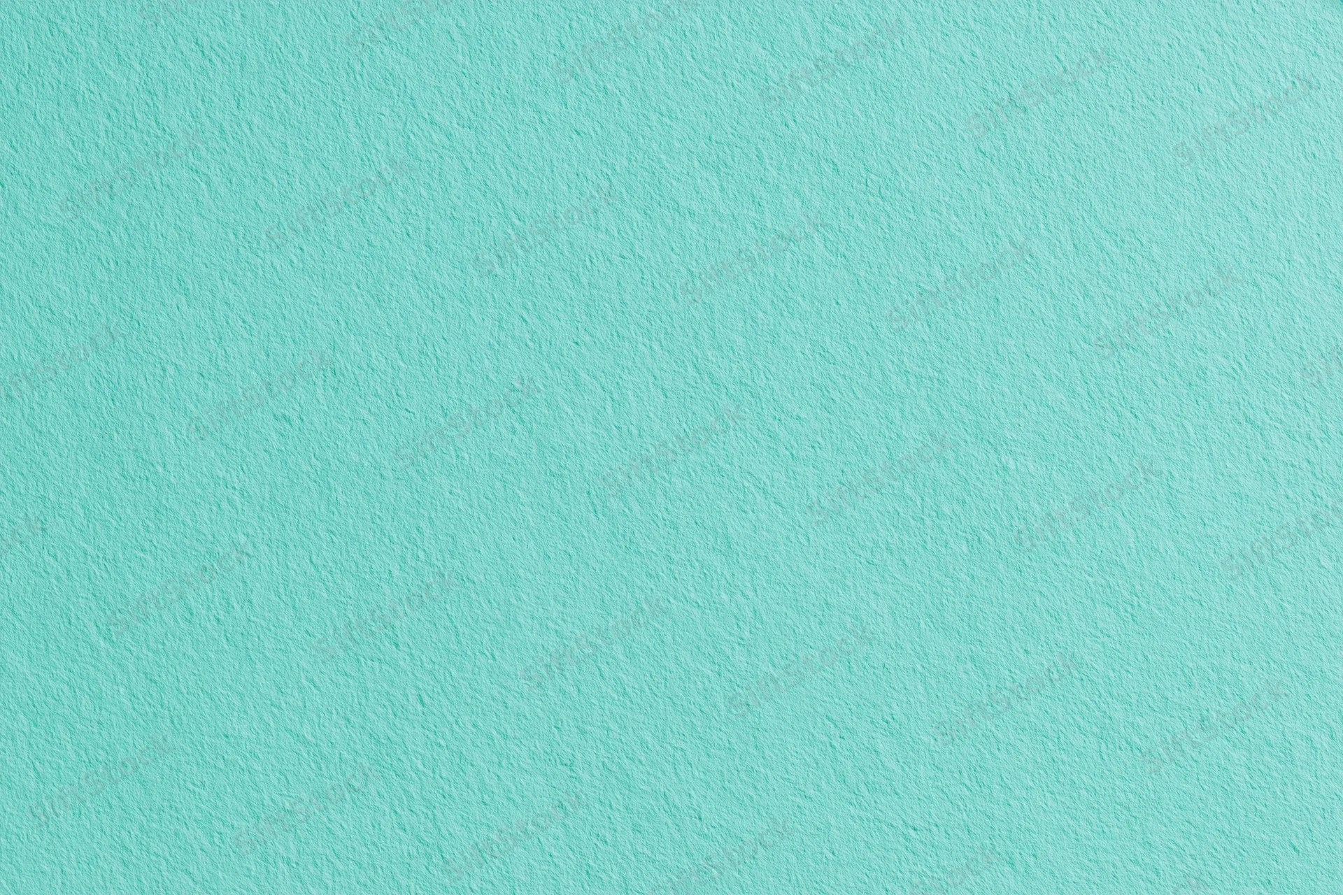 Flat matte turquoise painted wall surface filling the frame
