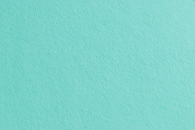 Flat matte turquoise painted wall surface filling the frame