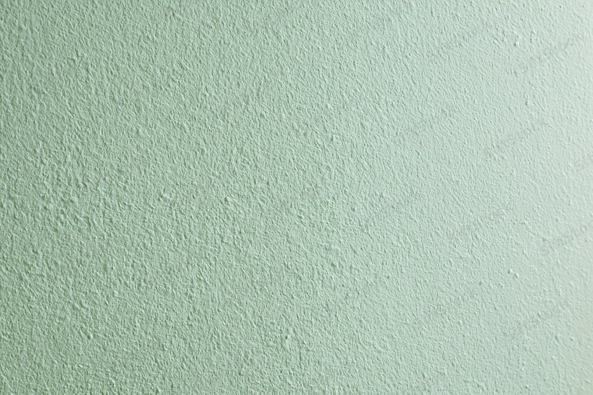 Close-up of a flat matte green painted wall surface filling the frame