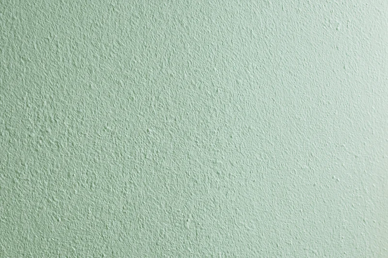 Close-up of a flat matte green painted wall surface filling the frame