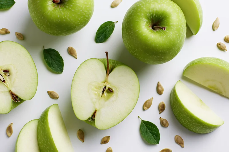 Green apple cut into halves and wedge slices arranged layout