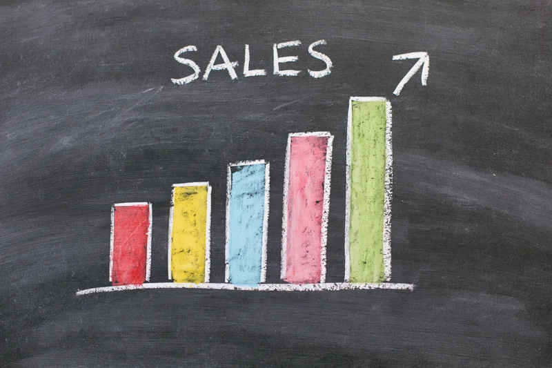 Hand-drawn chalk bar chart showing increasing sales on a blackboard